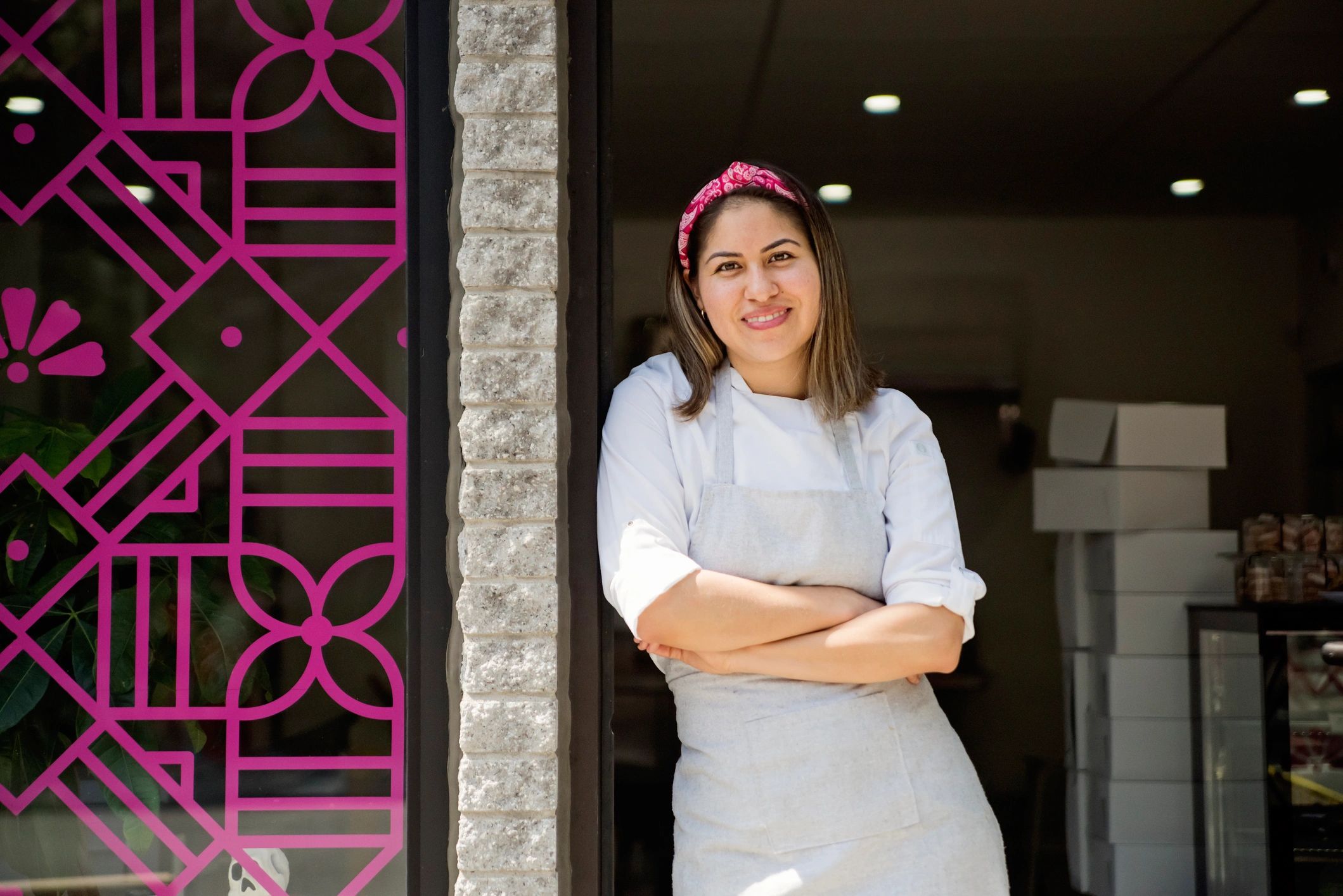 Small business owner standing in front of a storefront