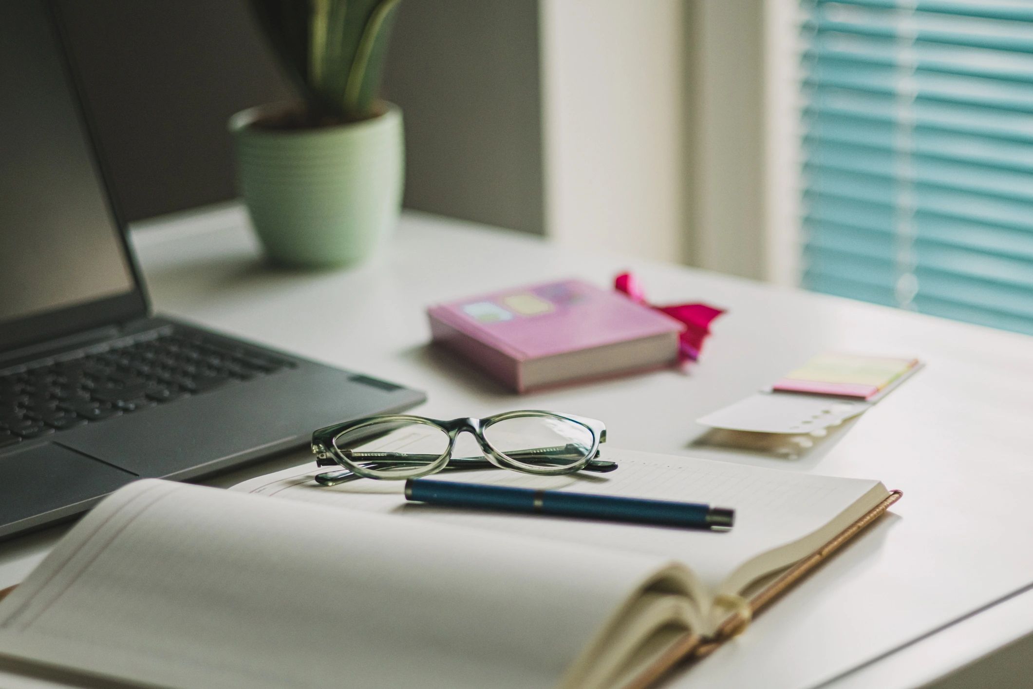 Laptop on a desk with workspace items