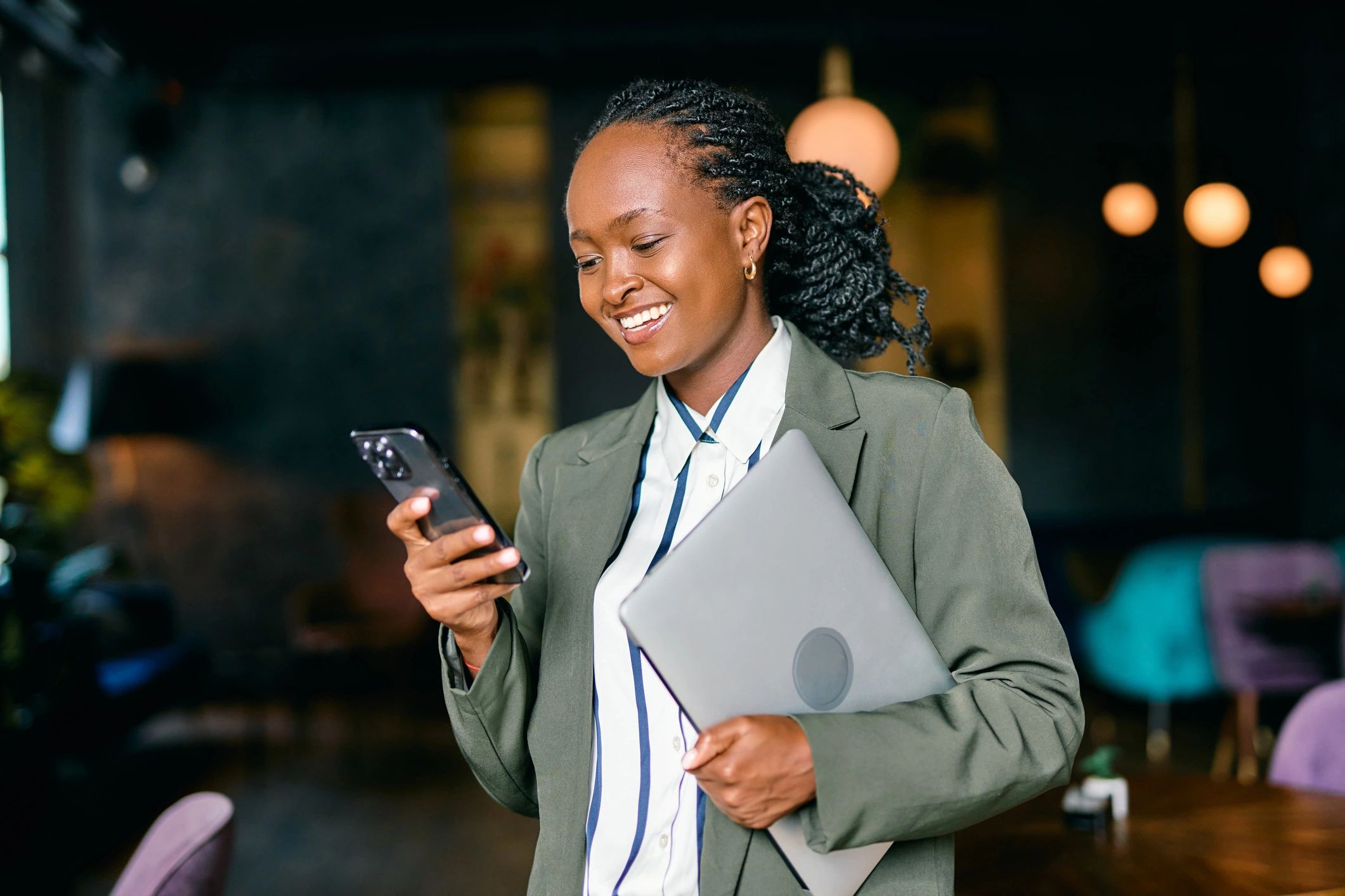 Smiling professional holding a laptop in a modern office