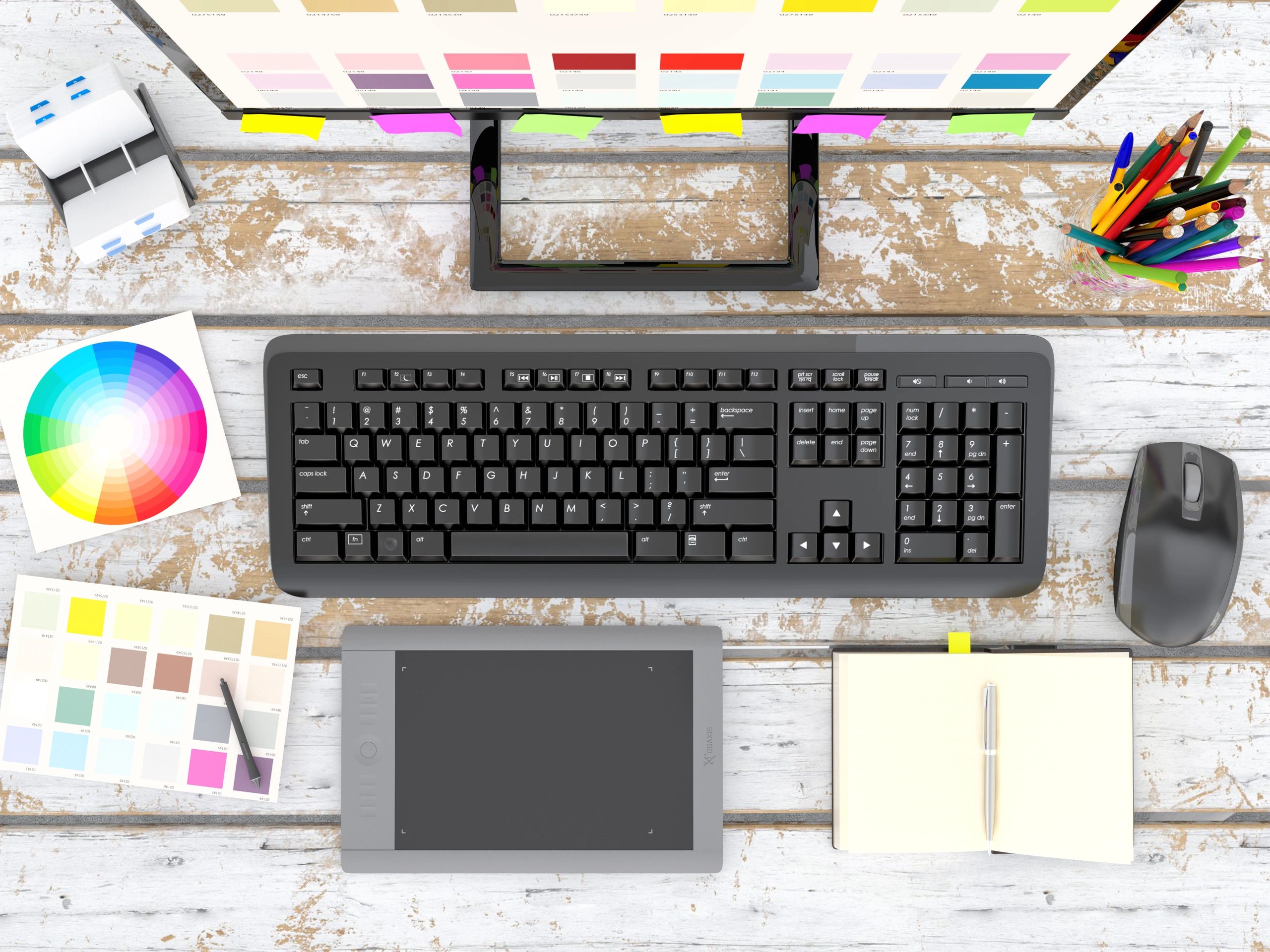 Overhead view of a graphic designer’s desk with tools and color materials